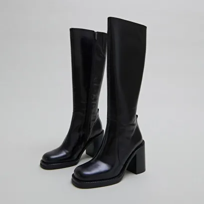 Boots with overflowing heels in black leather