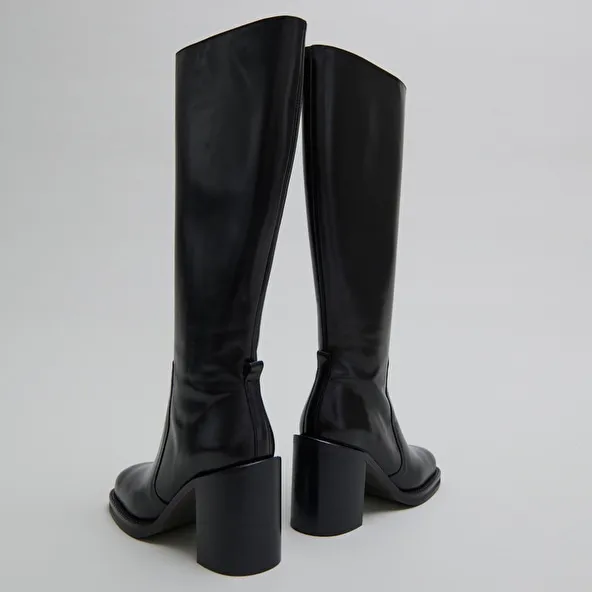 Boots with overflowing heels in black leather